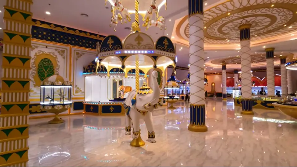 Grand hall with marble floors, ornate columns, and white elephant.