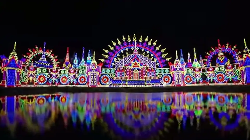 Symmetrical illuminated Carnival Magic facade reflected in water at night.