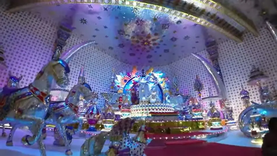 Grand hall with mirrored sculptures and a luminous central structure.