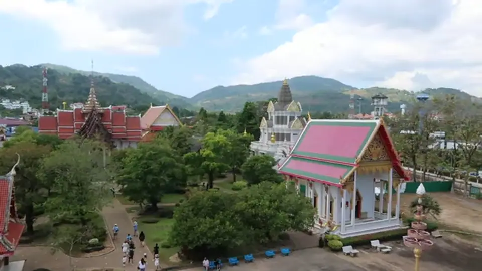 Elevated view of Wat Chalong temples, gardens, and hills.